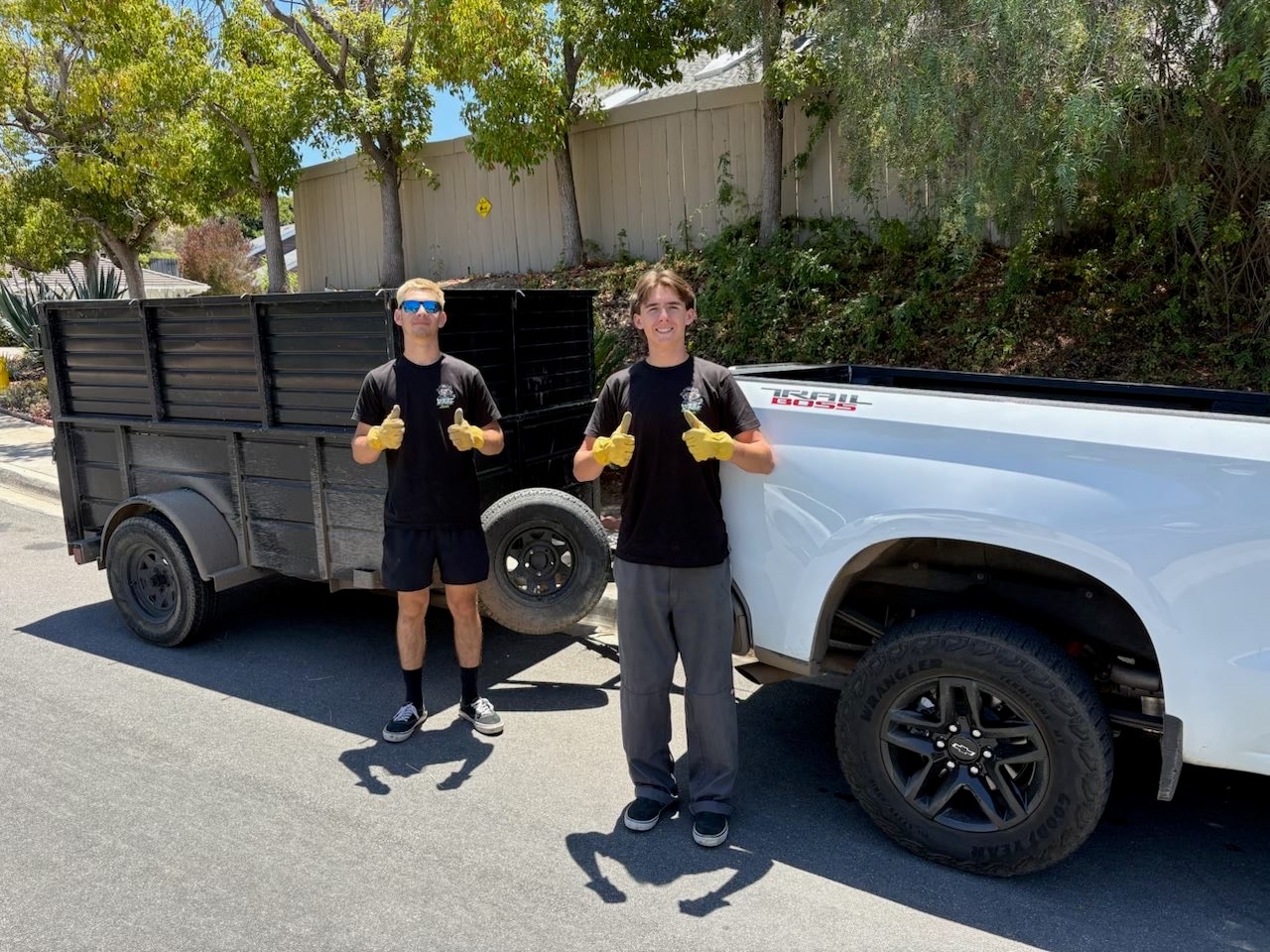 West Edge Junk Removal crew giving thumbs up with truck and trailer